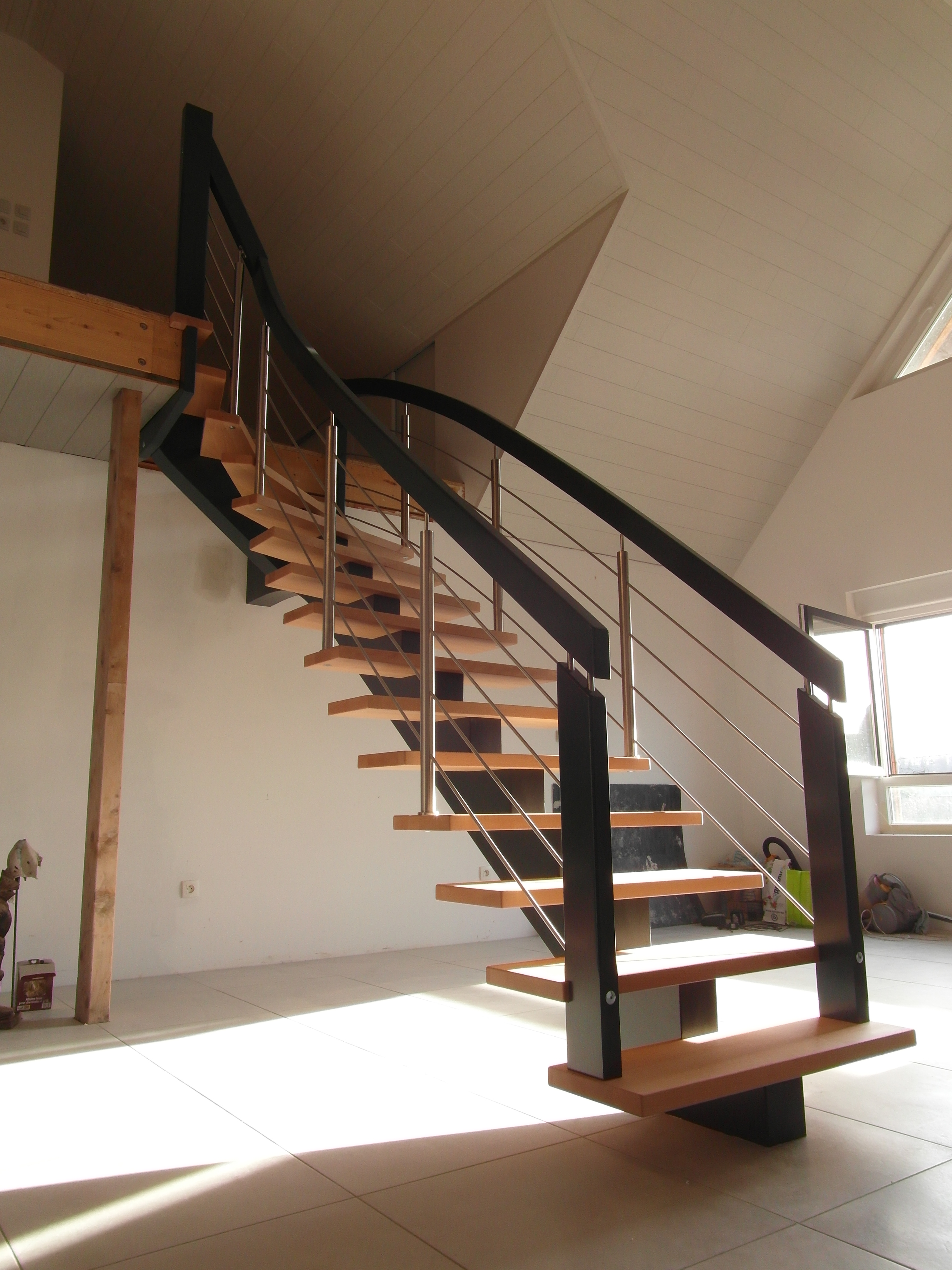 Escalier hélicoïdal contemporain avec mur en pierre apparente