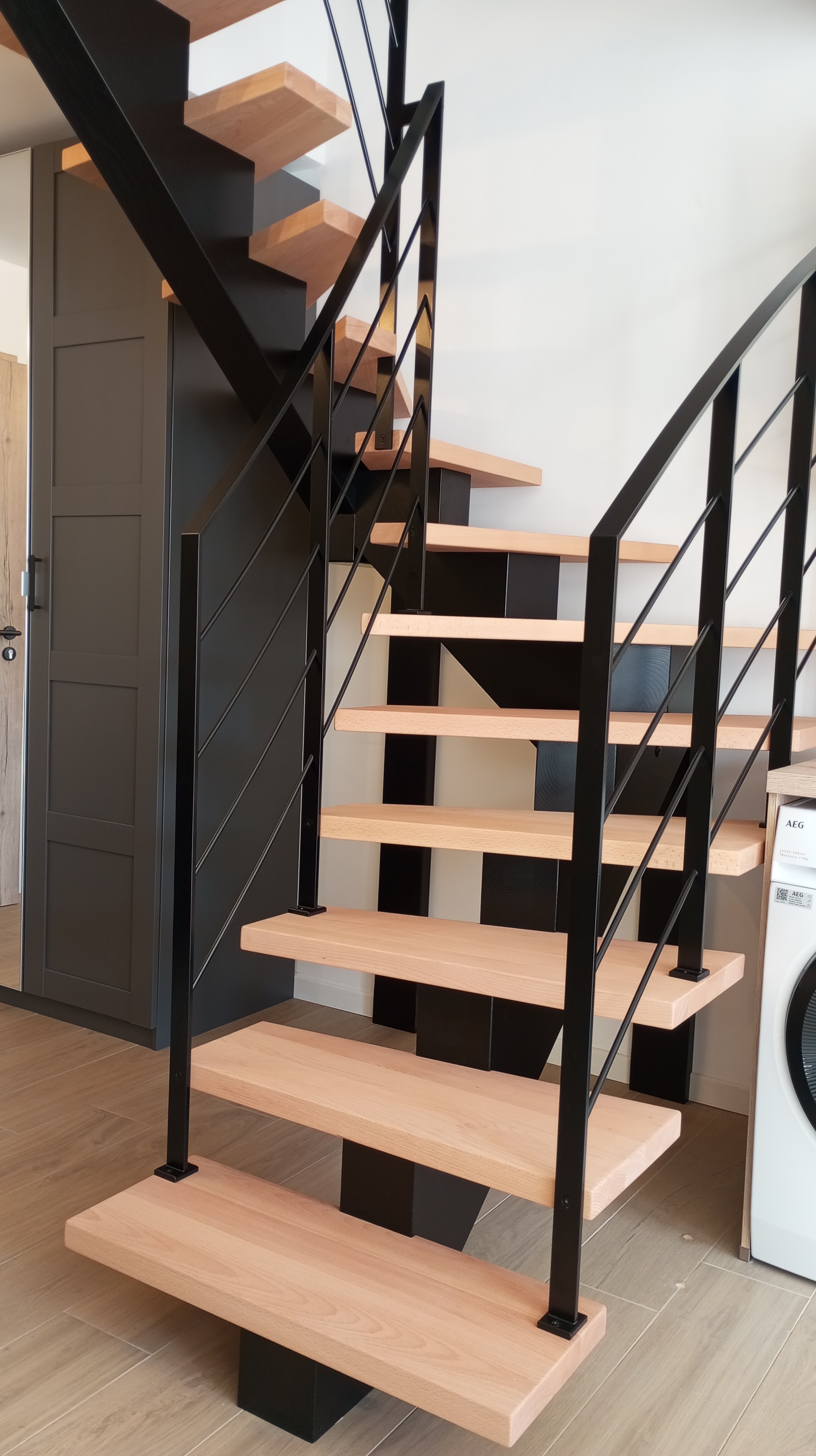 Escalier design bois clair avec rampe métal noire, exemple d'habillage soigné