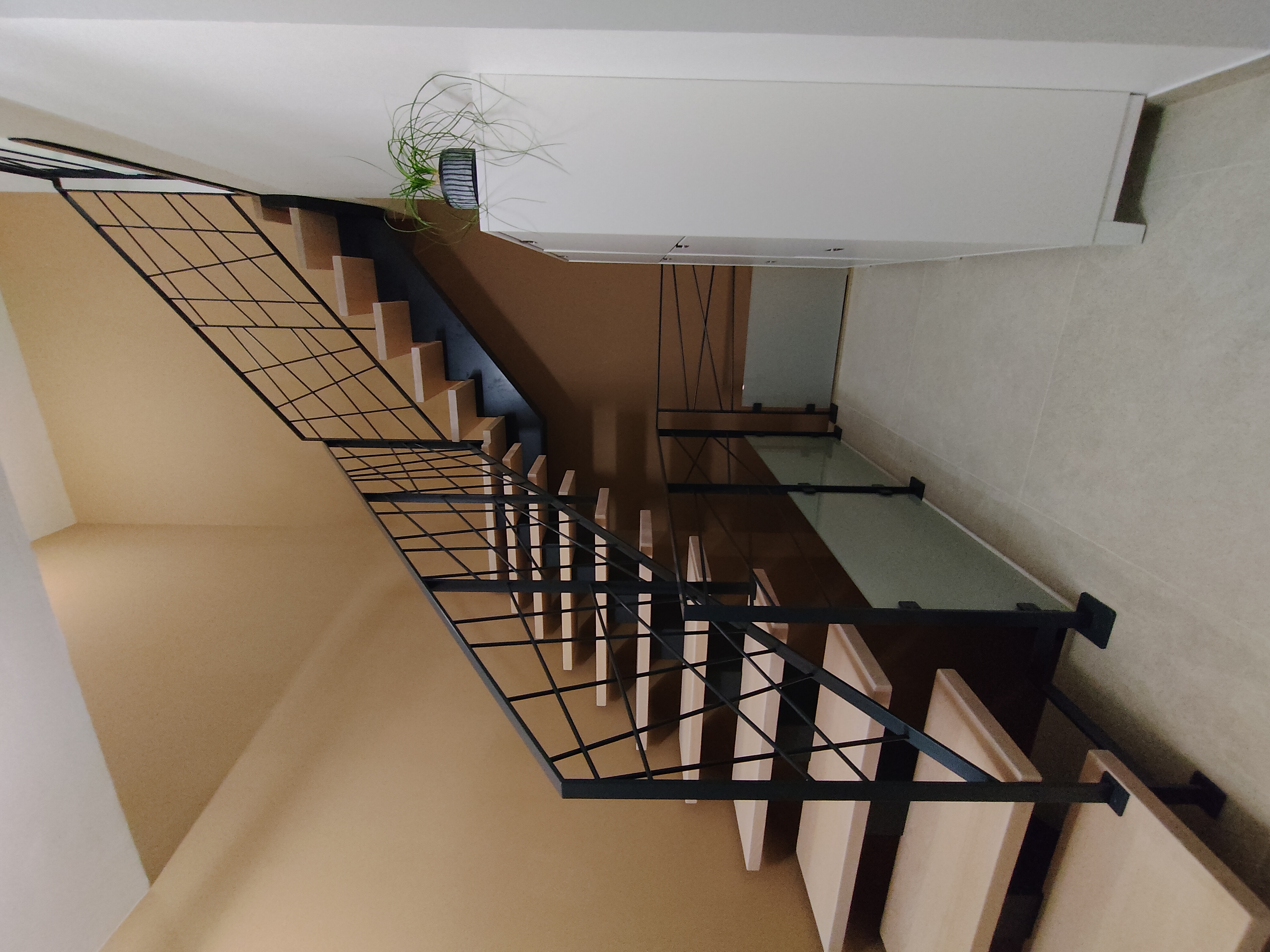 Escalier sur mesure en bois clair et verre dans un intérieur blanc lumineux